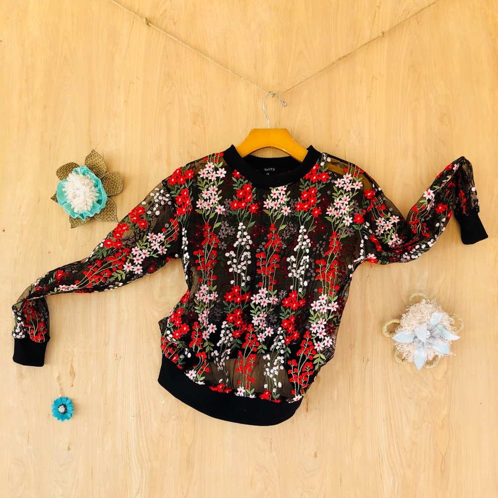 A black transparent top with a red floral print.